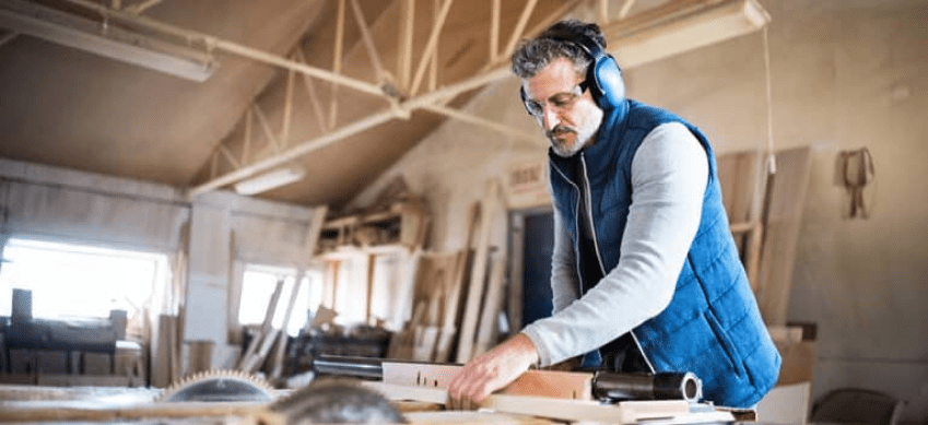 Woodworker creating on table in workshop.